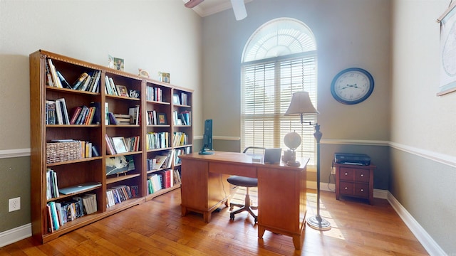 office area with hardwood / wood-style floors, a ceiling fan, and baseboards