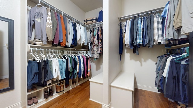walk in closet with wood finished floors