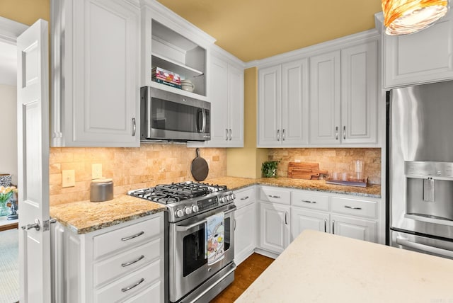 5715 Hawthorne Rd, Little Rock, AR 72207 - kitchen with white cabinets, decorative backsplash, light stone countertops, and stainless steel appliances