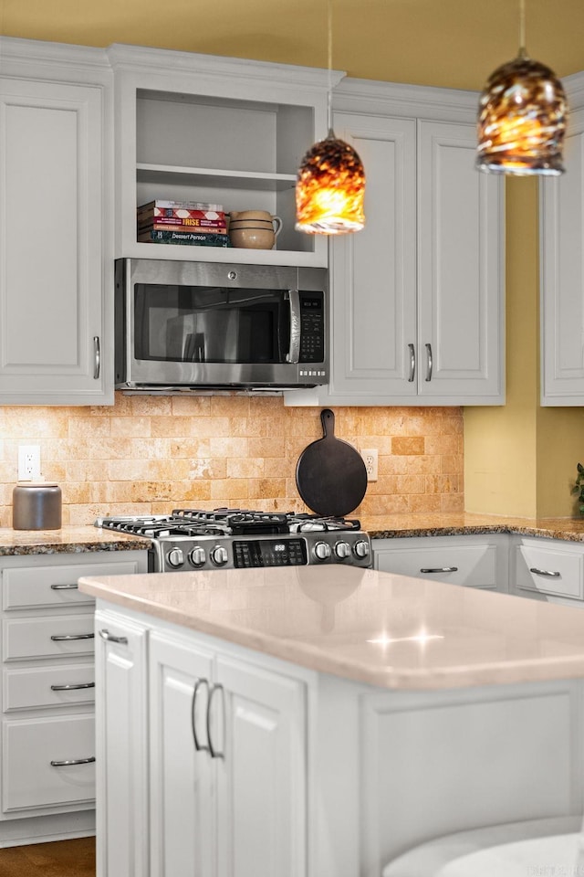 5715 Hawthorne Rd, Little Rock, AR 72207 - kitchen featuring stainless steel microwave, backsplash, and white cabinetry