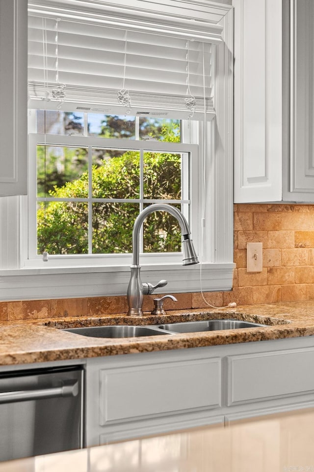 5715 Hawthorne Rd, Little Rock, AR 72207 - interior details with stainless steel dishwasher, a sink, decorative backsplash, stone counters, and white cabinets