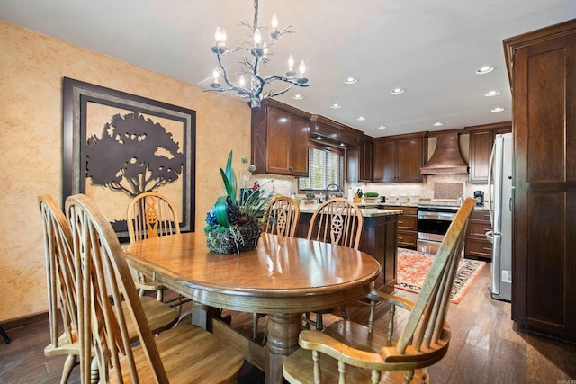 dining space with a notable chandelier, wood finished floors, and recessed lighting