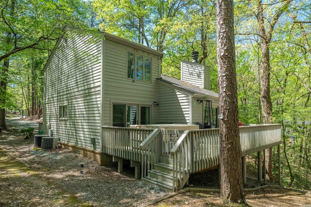 back of house with a wooden deck, crawl space, and a chimney