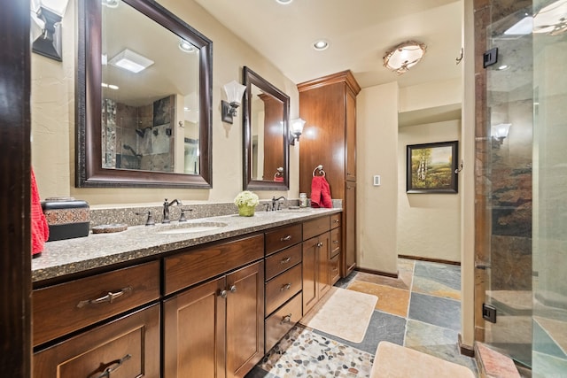 bathroom featuring a shower stall, stone finish floor, and a sink