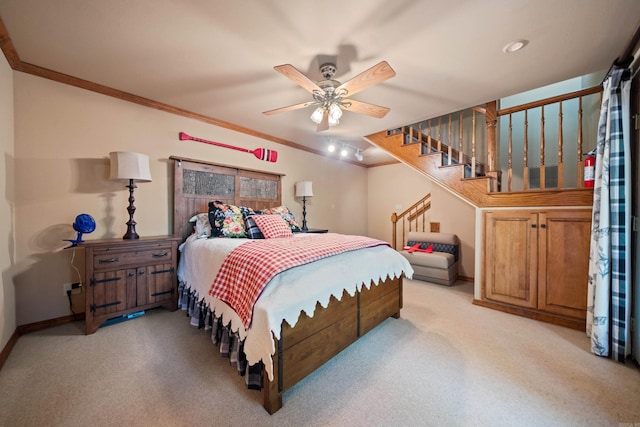 bedroom featuring light carpet, a ceiling fan, baseboards, and crown molding