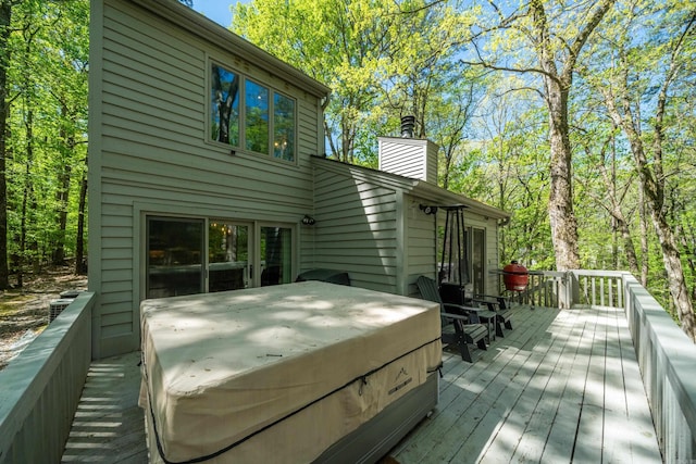 wooden deck with a hot tub