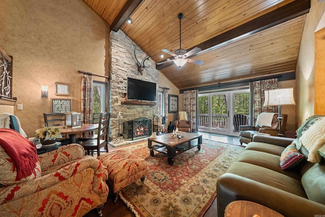 living area with high vaulted ceiling, beamed ceiling, ceiling fan, wooden ceiling, and a fireplace