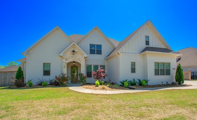 4941 Lake Vista Dr, Benton, AR 72019 - view of front facade with board and batten siding, a front lawn, and fence
