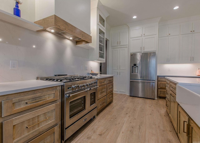 4941 Lake Vista Dr, Benton, AR 72019 - kitchen featuring white cabinets, stainless steel appliances, light wood-type flooring, custom range hood, and light countertops