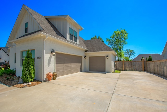 4941 Lake Vista Dr, Benton, AR 72019 - view of side of property featuring concrete driveway, board and batten siding, a shingled roof, fence, and brick siding