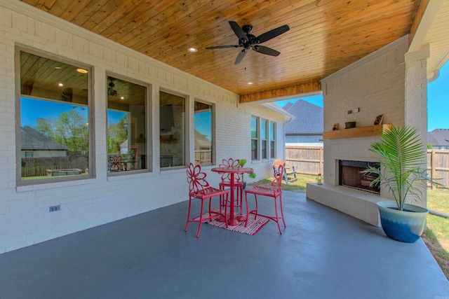 4941 Lake Vista Dr, Benton, AR 72019 - view of patio / terrace with fence, a ceiling fan, and an outdoor brick fireplace