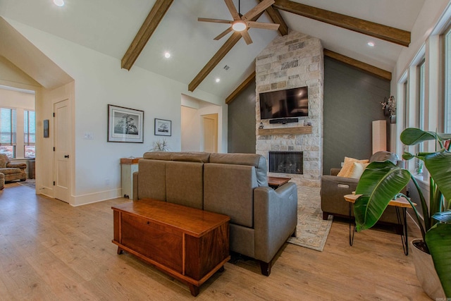 4941 Lake Vista Dr, Benton, AR 72019 - living room with a ceiling fan, a stone fireplace, beamed ceiling, and light wood-type flooring