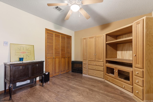 15 Falcon Dr, Sherwood, AR 72120 - bedroom featuring wood finished floors, a textured ceiling, a closet, ceiling fan, and visible vents