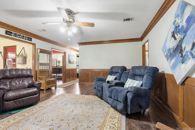 15 Falcon Dr, Sherwood, AR 72120 - living room featuring crown molding, a textured ceiling, a wainscoted wall, dark wood-type flooring, and visible vents