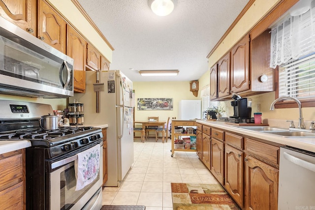 15 Falcon Dr, Sherwood, AR 72120 - kitchen with stainless steel appliances, light countertops, a sink, and a textured ceiling