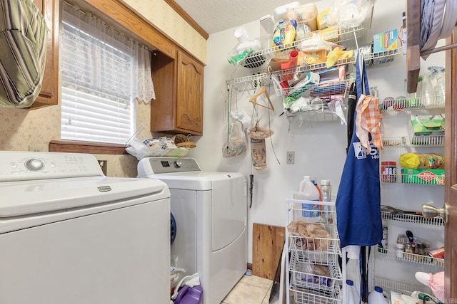 15 Falcon Dr, Sherwood, AR 72120 - clothes washing area with cabinet space, a textured ceiling, washing machine and clothes dryer, and light tile patterned flooring