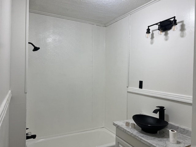 bathroom featuring vanity, a textured ceiling, and tub / shower combination