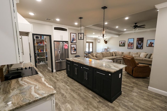 kitchen featuring freestanding refrigerator, visible vents, crown molding, dark cabinets, and black electric stovetop