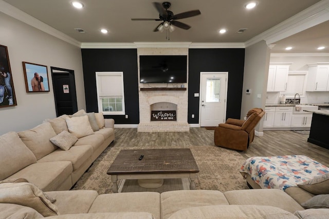 living room featuring crown molding, wood finished floors, visible vents, and a ceiling fan