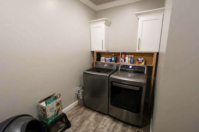 laundry room featuring light wood-style flooring, baseboards, separate washer and dryer, cabinet space, and ornamental molding