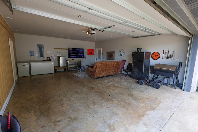 garage featuring fridge, electric panel, and a garage door opener