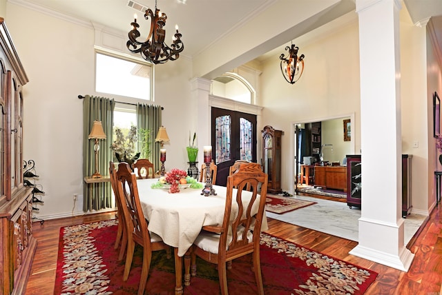 2780 Shoemaker Rd, Sheridan, AR 72150 - dining room featuring a notable chandelier, ornate columns, wood finished floors, a high ceiling, and crown molding