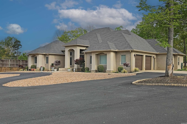 2780 Shoemaker Rd, Sheridan, AR 72150 - french country home with fence, driveway, a shingled roof, and a garage