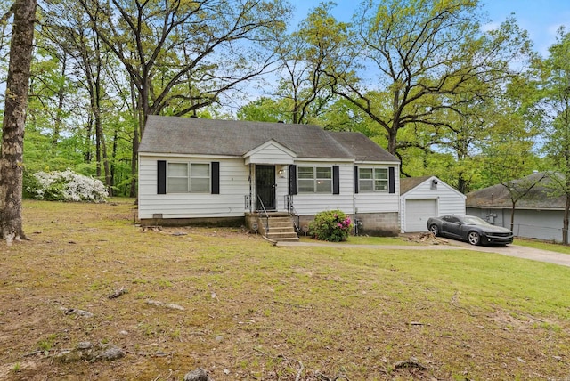 7803 Ascension Rd, Little Rock, AR 72204 - view of front of house with a front lawn, aphalt driveway, an outbuilding, and a detached garage