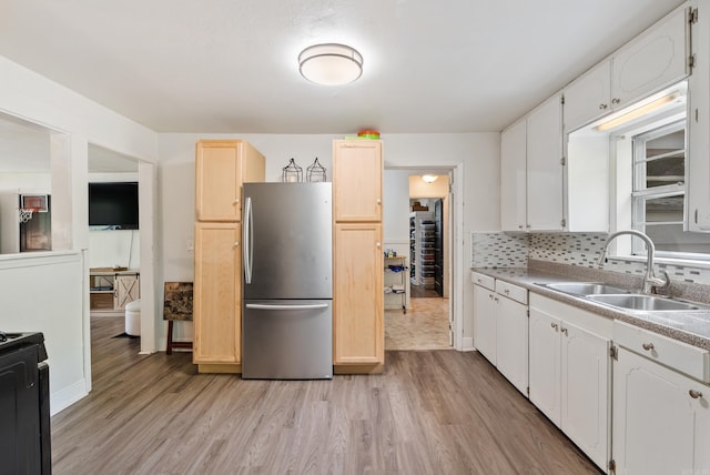 7803 Ascension Rd, Little Rock, AR 72204 - kitchen with baseboards, light wood-style flooring, freestanding refrigerator, and a sink