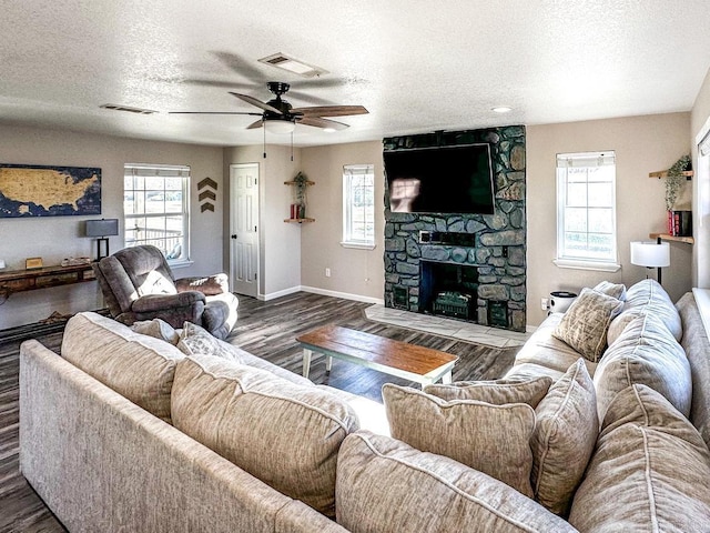 living room with a wealth of natural light, a textured ceiling, and visible vents