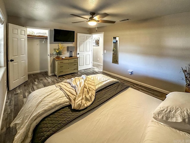 bedroom featuring baseboards, visible vents, a ceiling fan, wood finished floors, and a closet