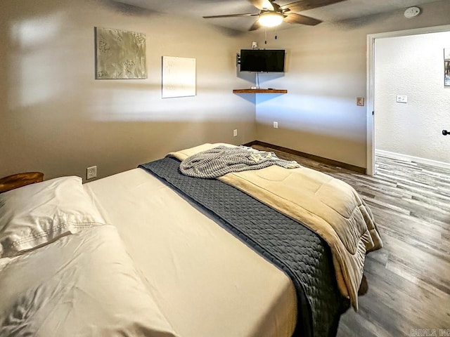 bedroom with baseboards and wood finished floors