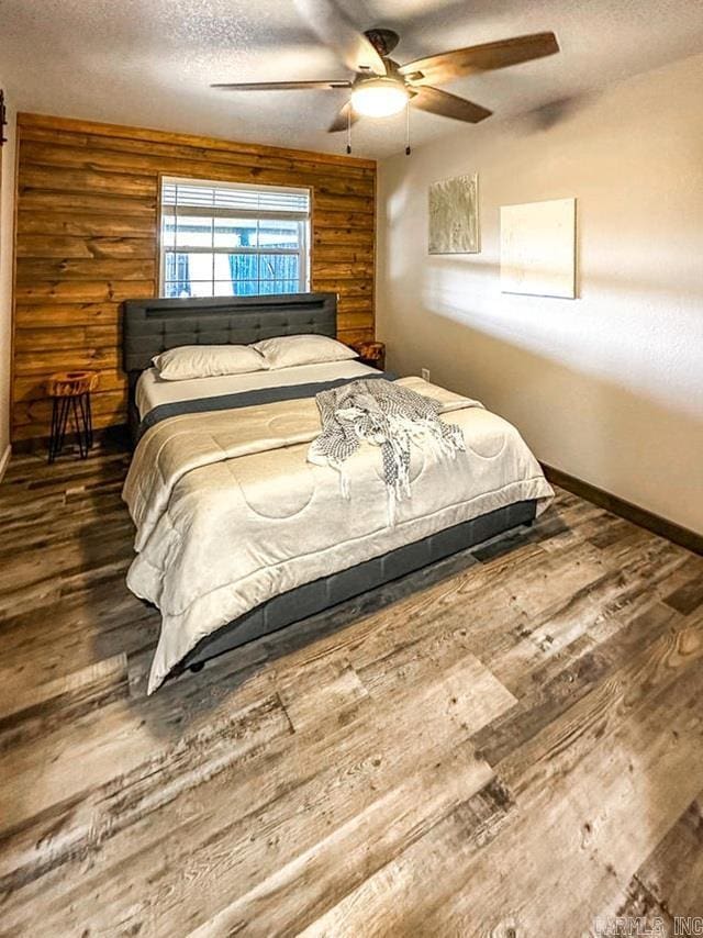 bedroom with baseboards, a textured ceiling, hardwood / wood-style flooring, and ceiling fan