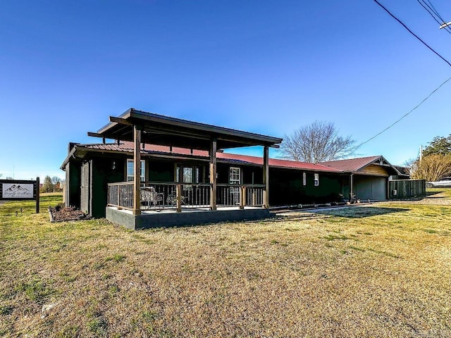 back of property featuring a yard and metal roof