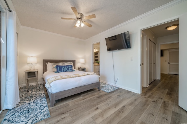 bedroom featuring light wood-type flooring, a textured ceiling, crown molding, and baseboards