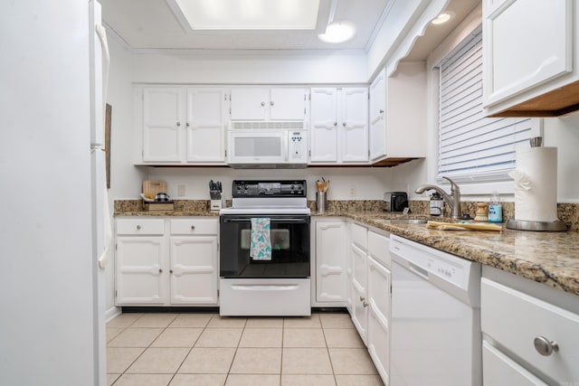 kitchen featuring white cabinetry, a sink, white appliances, and light tile patterned floors