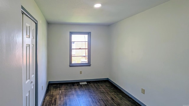 interior space with baseboards, visible vents, and dark wood-style floors