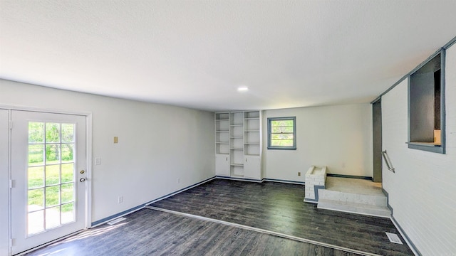 interior space featuring dark wood finished floors, visible vents, and baseboards