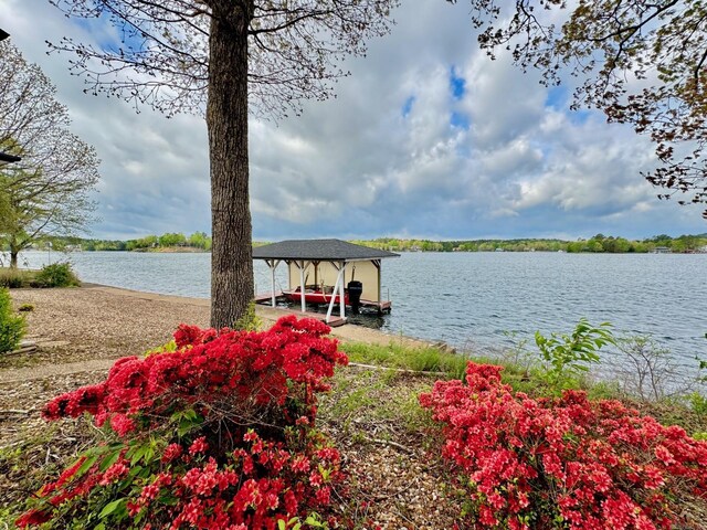view of dock with boat lift and a water view