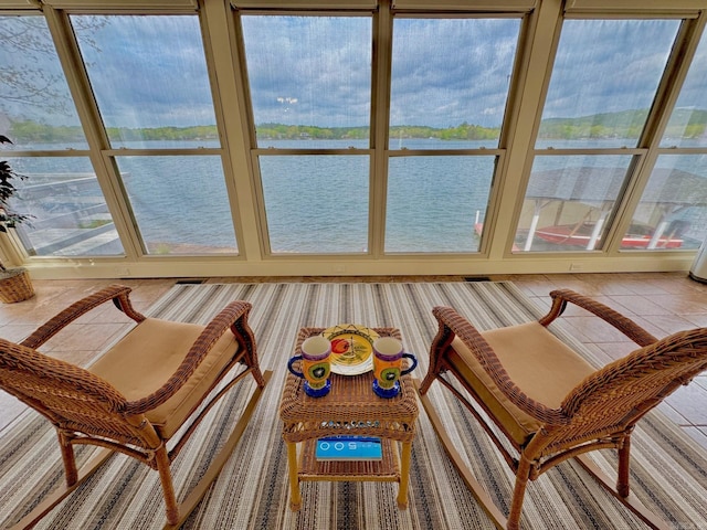 sunroom featuring a water view and tile patterned floors