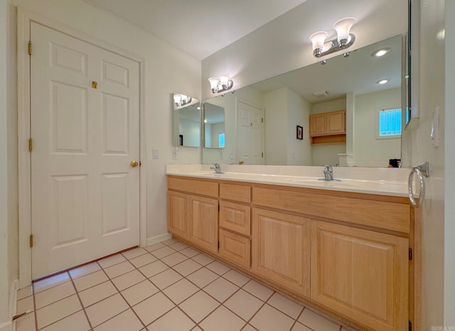full bathroom with baseboards, tile patterned floors, a sink, and double vanity