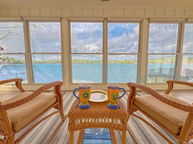 sunroom featuring a water view