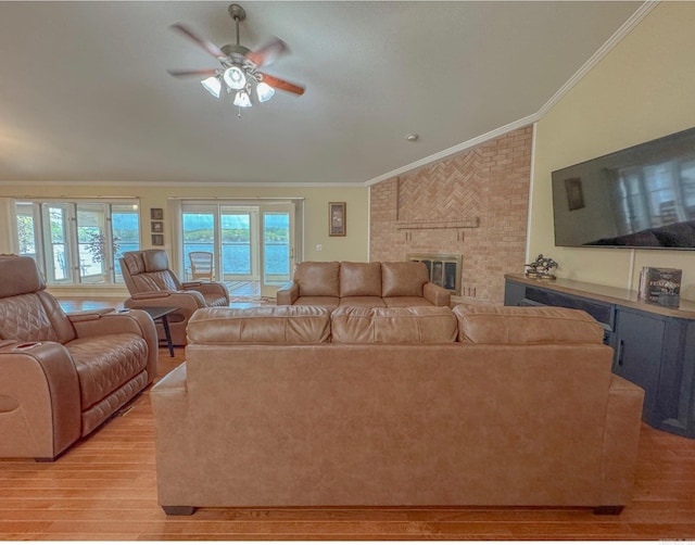 living room with light wood-type flooring, a healthy amount of sunlight, and ornamental molding