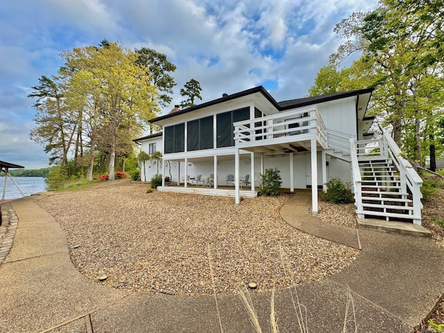 exterior space featuring a wooden deck, a sunroom, and stairs