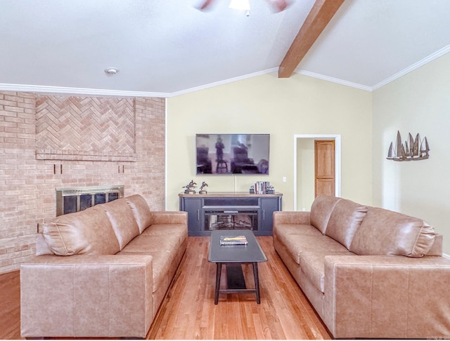 living area with light wood finished floors, lofted ceiling with beams, a ceiling fan, and a fireplace