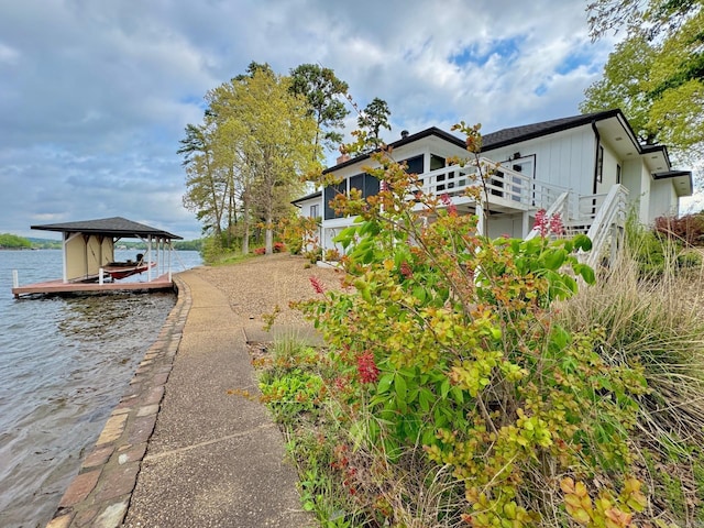 exterior space with stairs, a water view, and boat lift