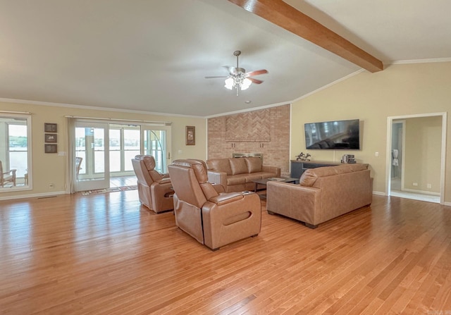 living area with a brick fireplace, a wealth of natural light, light wood-style floors, and ceiling fan