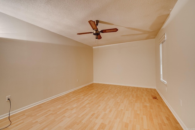 unfurnished room featuring ceiling fan, a textured ceiling, visible vents, vaulted ceiling, and light wood-type flooring