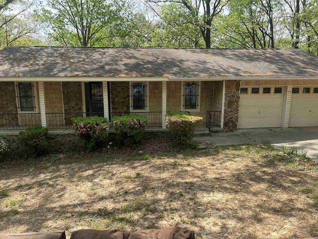 ranch-style home with a garage, stone siding, roof with shingles, concrete driveway, and a porch