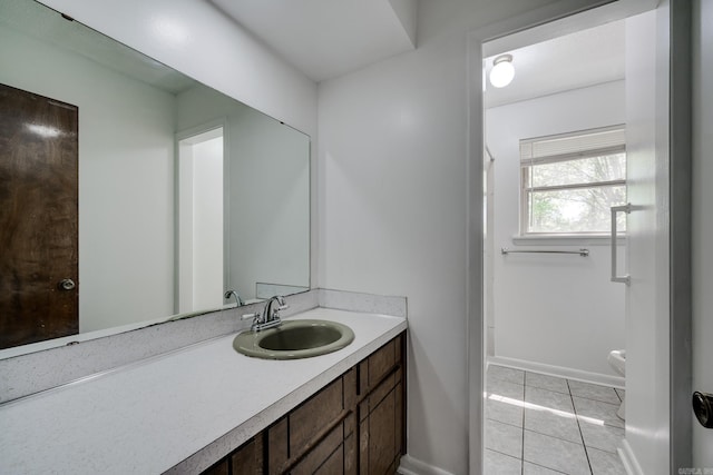 bathroom with toilet, baseboards, tile patterned flooring, and vanity